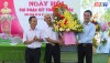 Đồng chí Nguyễn Văn Tình, Phó Chủ tịch UBND thị xã Ba Đồn tặng hoa chúc mừng ngày hội Đại đoàn kết