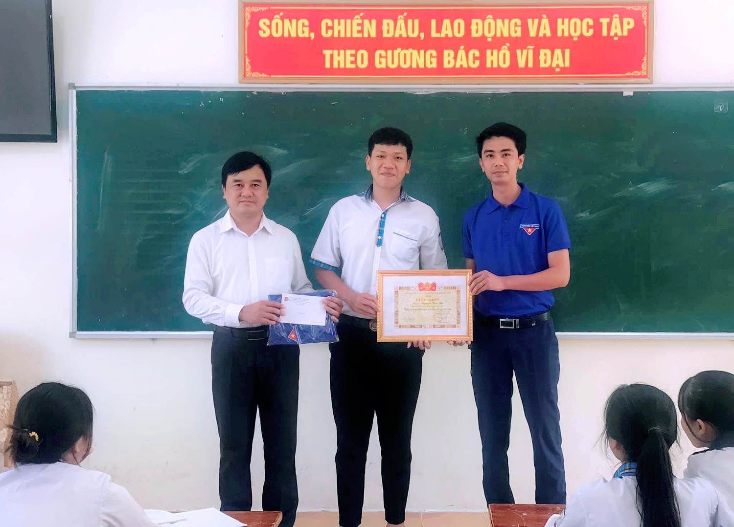 Anh Hồ Anh Dũng, Phó Bí thư Thị đoàn và thầy giáo Trần Thanh Hải, Phó Hiệu trưởng trường THPT Lương Thế Vinh trao giấy khen cho em Nguyễn Tiến Bắc