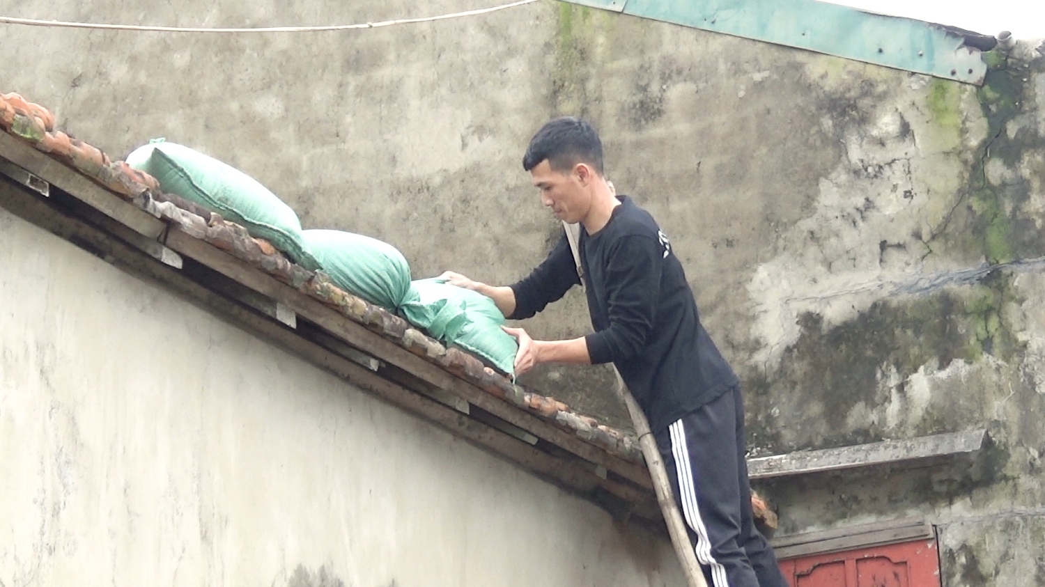 Người dân tại phường Quảng Phúc đang gia cố lại mái nhà trước cơn bão số 13