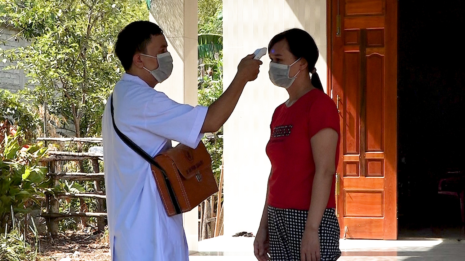 Trạm Y tế xã Quảng Tiên đo thân nhiệt cho người dân về cách ly tại nhà