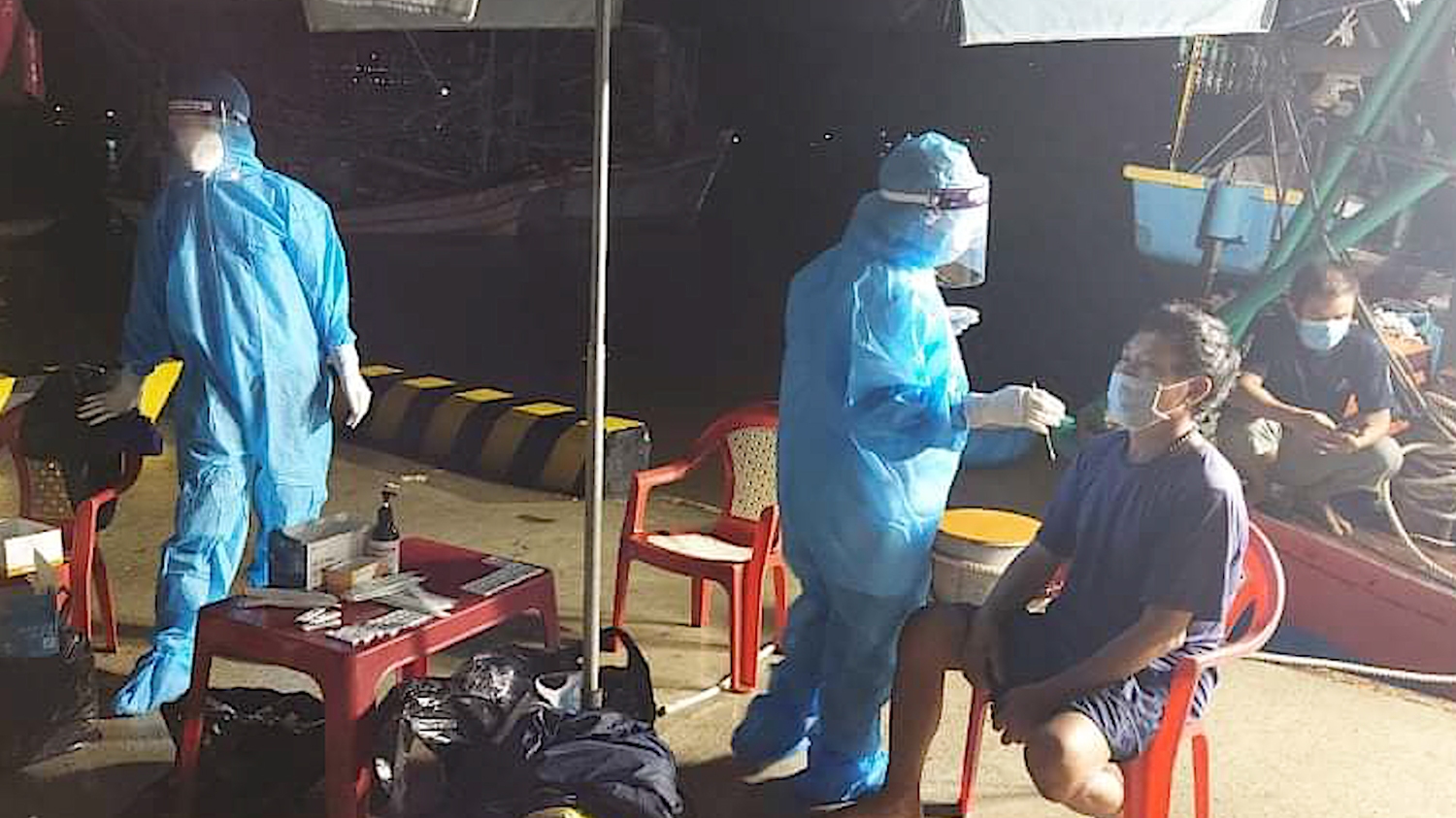 Đội ngũ y tế đang tiến hành lấy mẩu test nhanh cho các thuyền viên vào bờ tại phường Quảng Phúc,