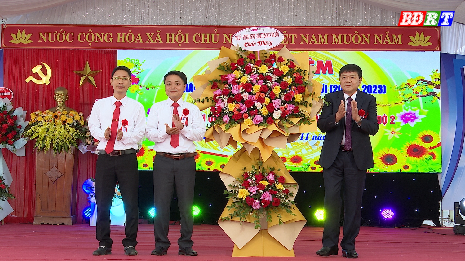 Đồng chí Đoàn Minh Thọ Phó Bí thư Thị ủy Chủ tịch UBND thị xã tặng hoa chúc mừng tập thể trường THPT Lê Lợi