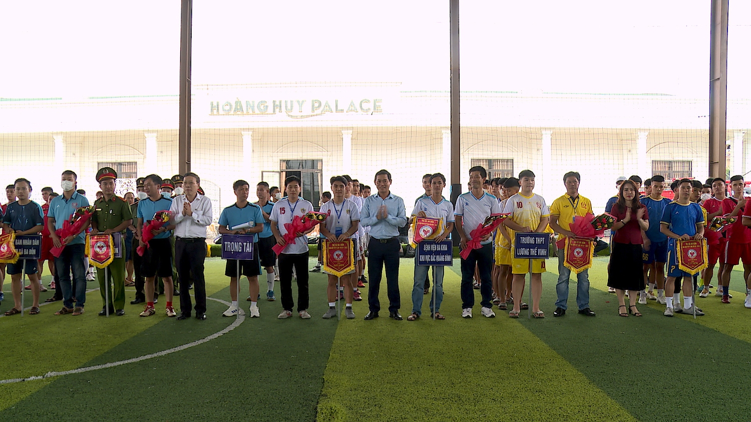 Ban tổ chức trao cờ lưu niệm và hoa cho các đội bóng.