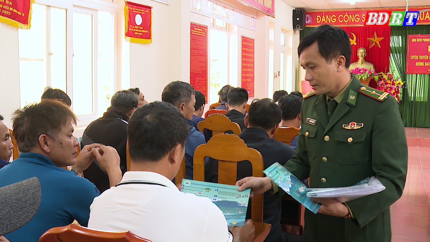 Cán bộ Đồn Biên phòng CK Cảng Gianh phát tờ rơi tuyên truyền pháp luật cho ngư dân