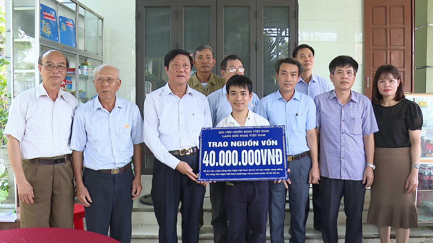 Ông Nguyễn Thăng Long- Giám đốc Làng Hữu nghị Việt Nam tại Hà Nội và đồng chí Trần Thanh Hưng- Trưởng Ban Dân vận Thị ủy trao hỗ trợ.