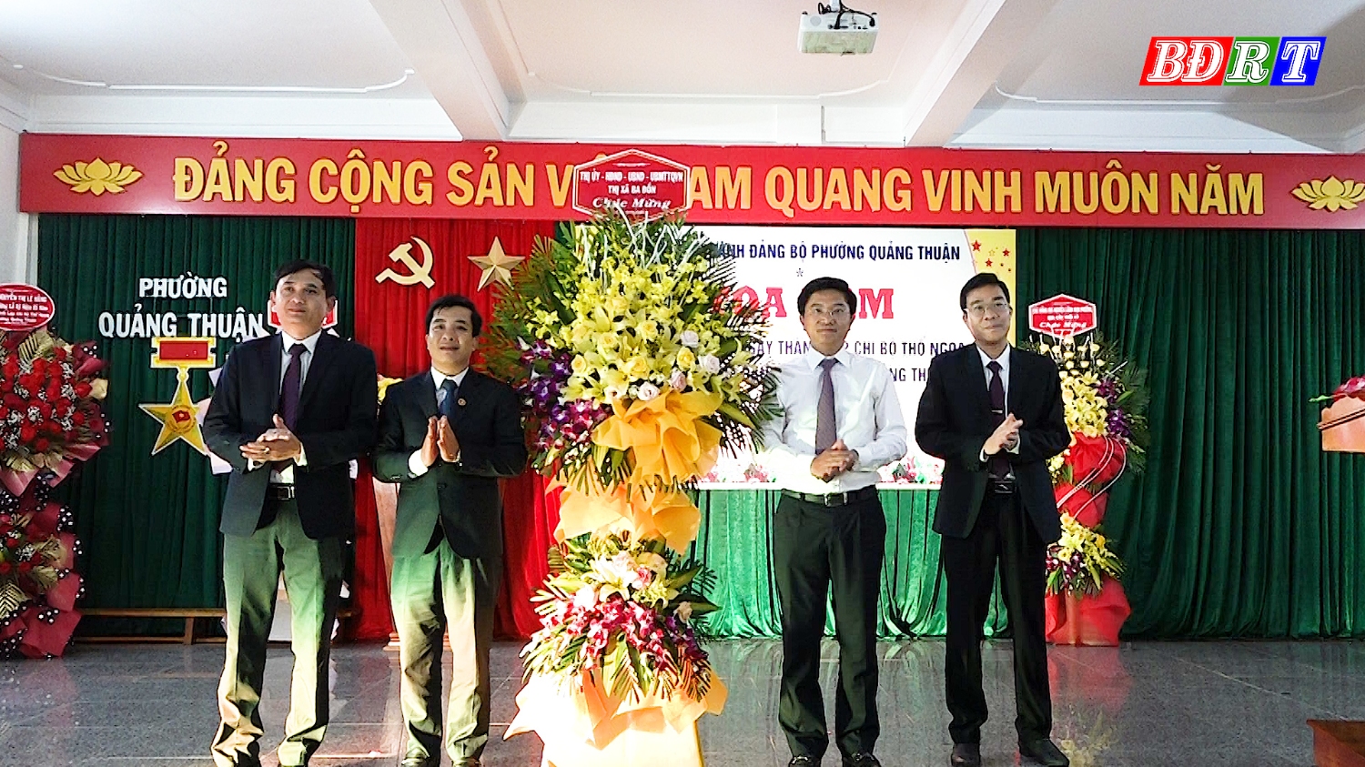 Đồng chí Bí thư Thị ủy Ba Đồn tặng hoa chúc mừng đảng bộ và nhân dân phường tại buổi tọa đàm.