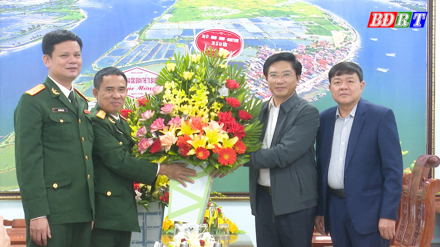 Đồng chí Bí thư Thị ủy và đồng chí Chủ tịch UBND thị xã tặng hoa chức mừng cán bộ, chiến sỹ  Ban CHQS thị xã.
