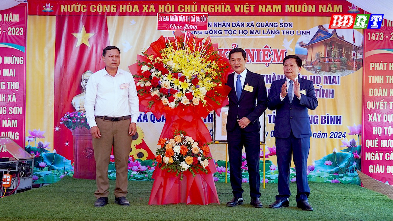 Đồng chí Nguyễn Văn Tình ThUV Phó Chủ tịch UBND thị xã Ba Đồn tặng hoa chúc mừng dòng họ Mai làng Thọ Linh
