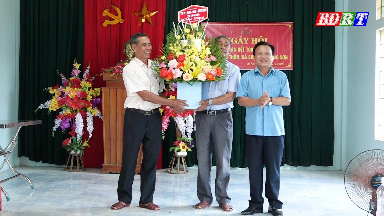 Đồng chí Phạm Duy Quang- PBT TT Thị ủy, Chủ tịch HĐND thị xã Ba Đồn tặng hoa chúc mừng ngày hội.