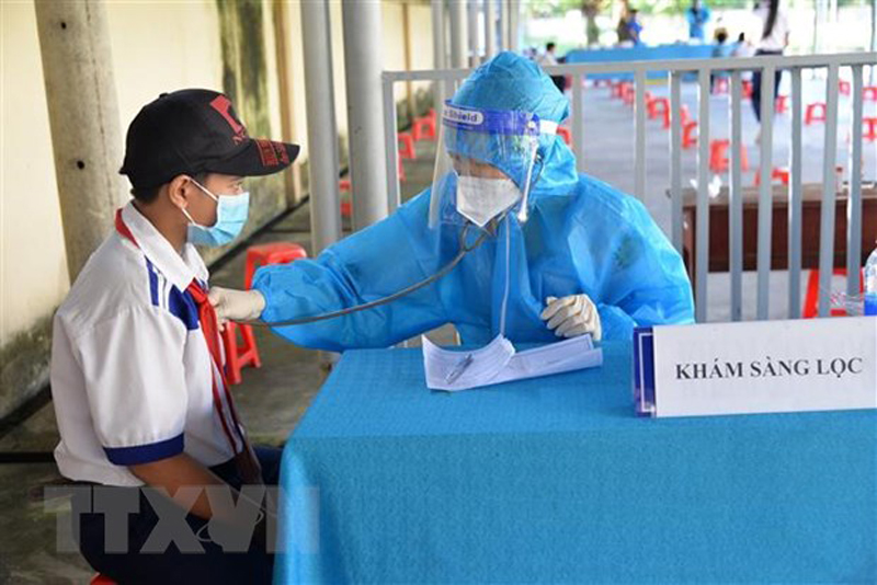 Khám sàng lọc cho học sinh trong độ tuổi trước khi tiêm vaccine phòng COVID-19. (Ảnh: Hữu Chí/TTXVN)