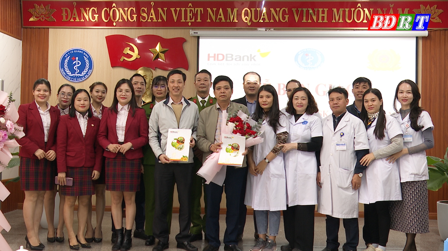 Lãnh đạo Ngân hàng Thương mại Cổ phần Phát triển TP Hồ Chí Minh Chi nhánh Quảng Bình tặng hoa bàn giao KIOSK Y tế thông minh cho Trung tâm Y tế thị xã